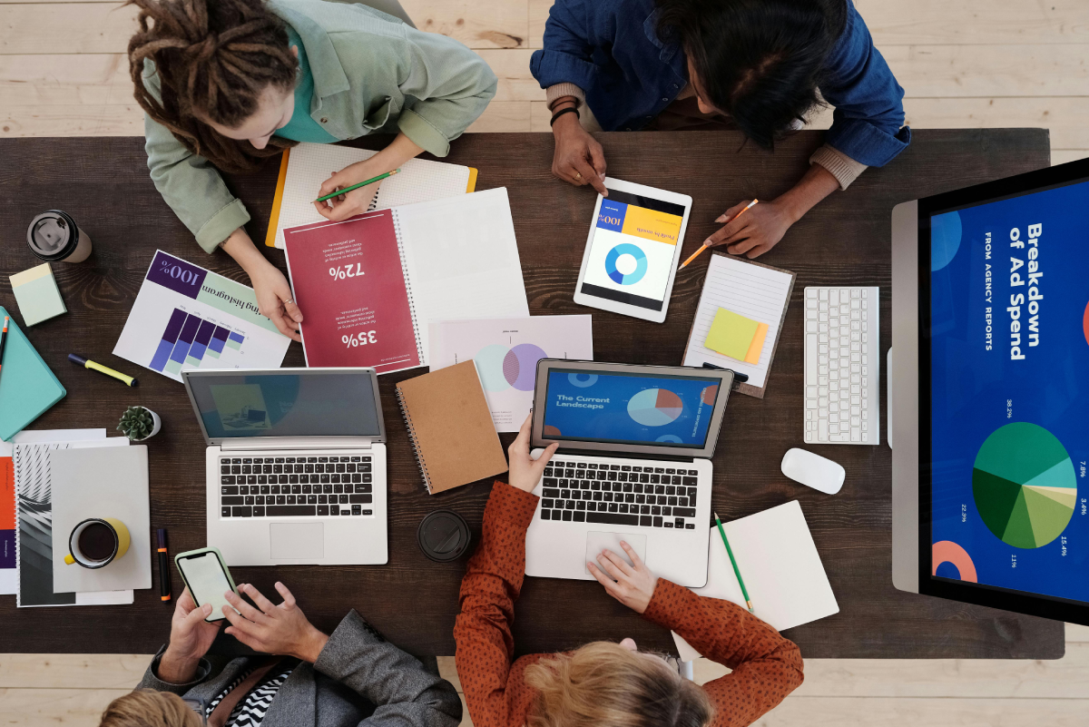 A Content Management and Creation Meeting with "Breakdown of Ad Spend" presentation open on a desktop