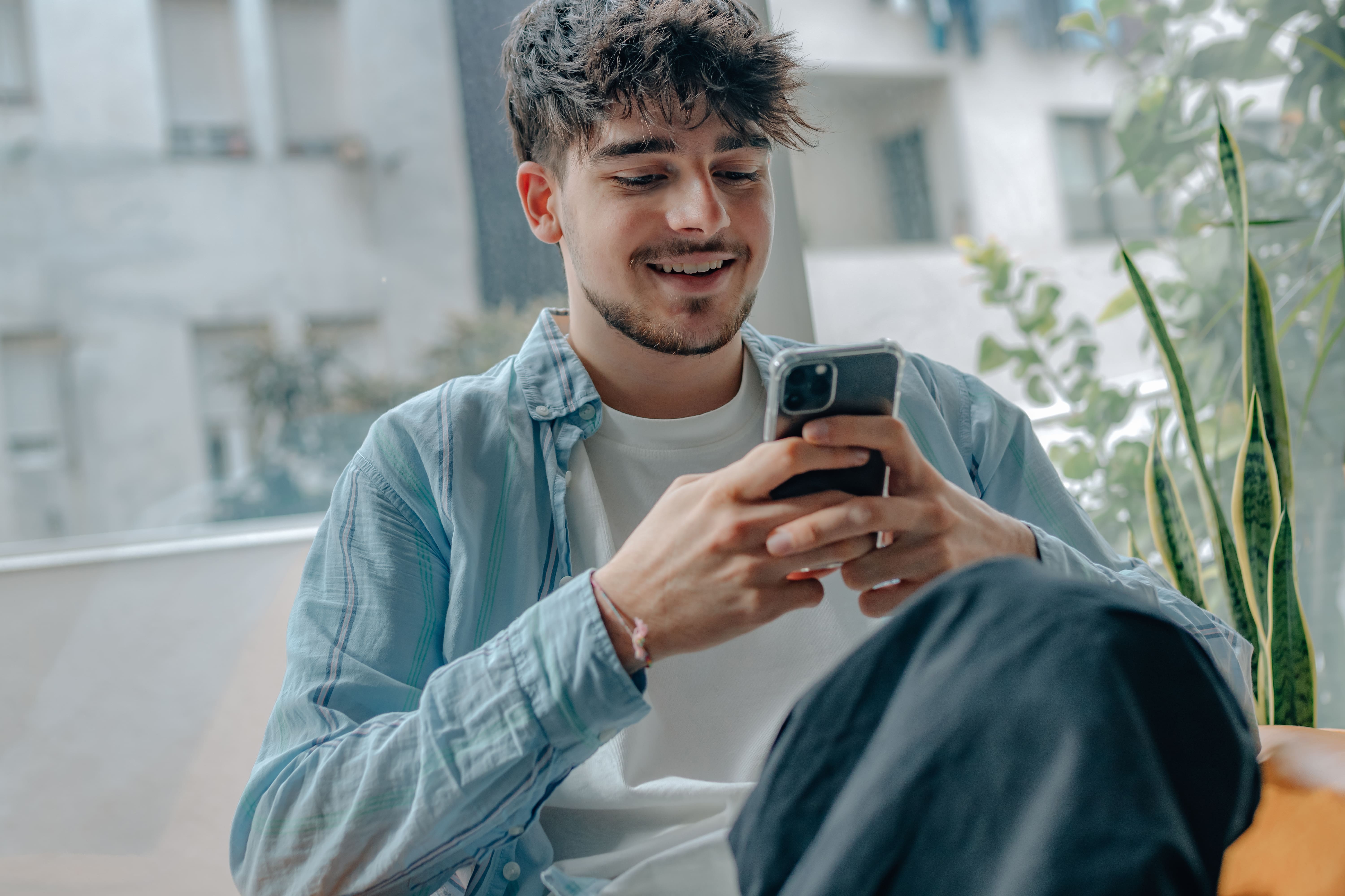 Man on his smartphone in his living room.