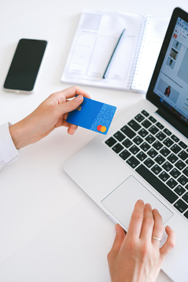 A person entering card details into a website using a laptop