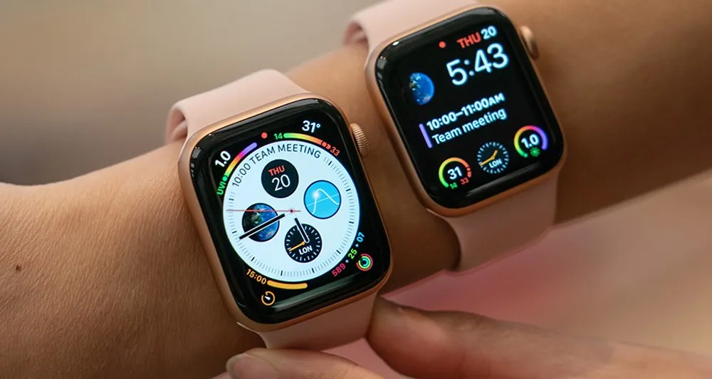 Two apple watches on a persons wrist displaying digital and analogue watch faces.