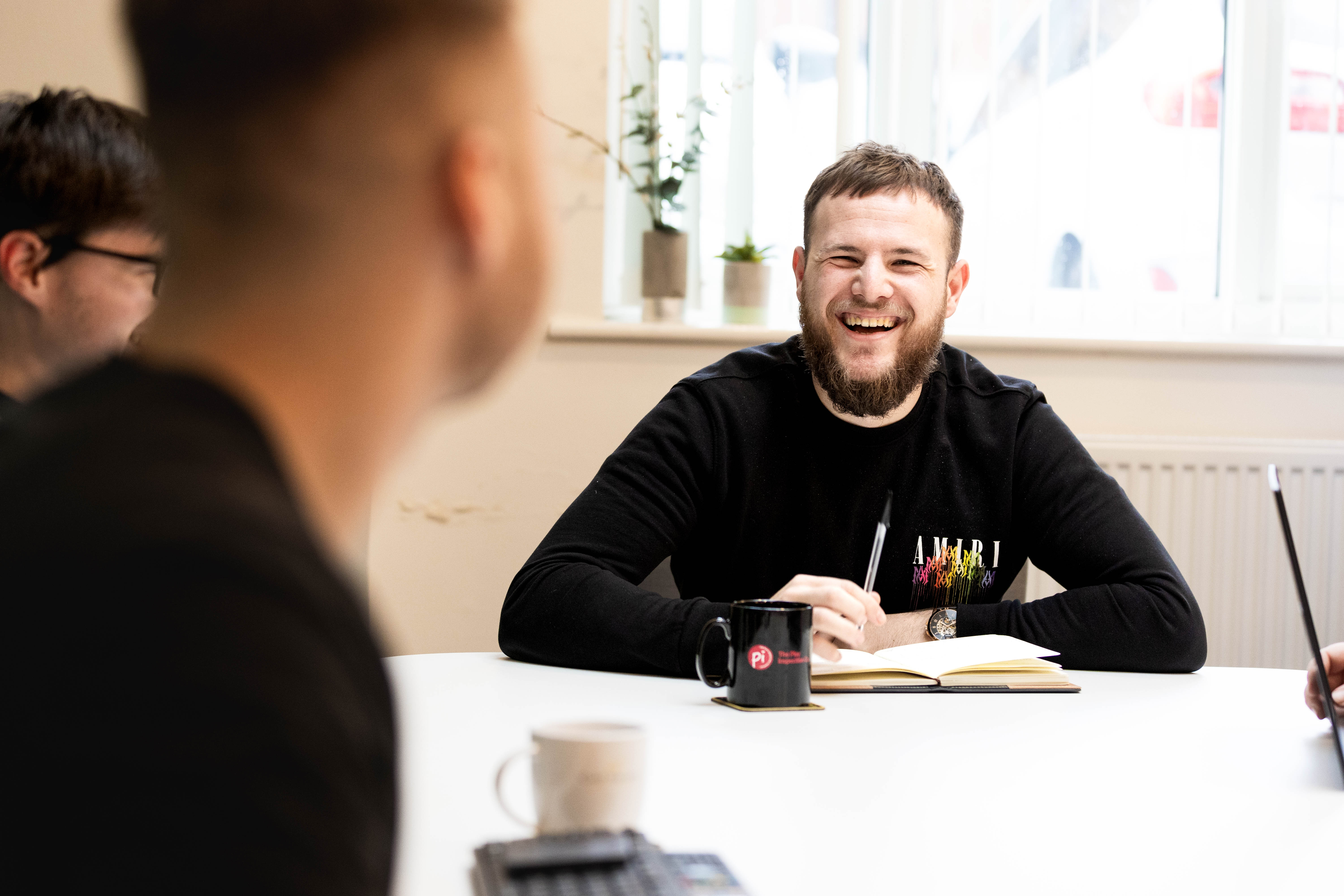 Two Cold Banana employees smiling at each other in a meeting room.