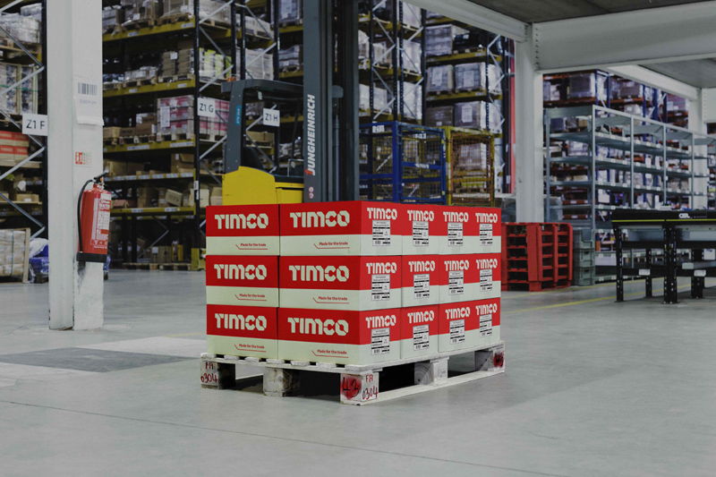 TIMCO branded boxes stacked onto a pallet in a warehouse.