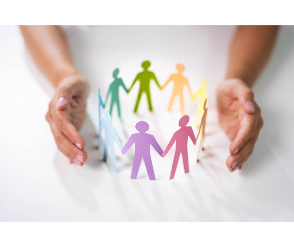 A circle of people cut out of different pieces of coloured paper, with a person holding their hands around the sides of the circle