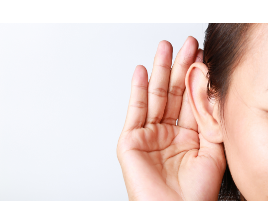 A person holding their hand to their ear as if trying to listen harder to a conversation