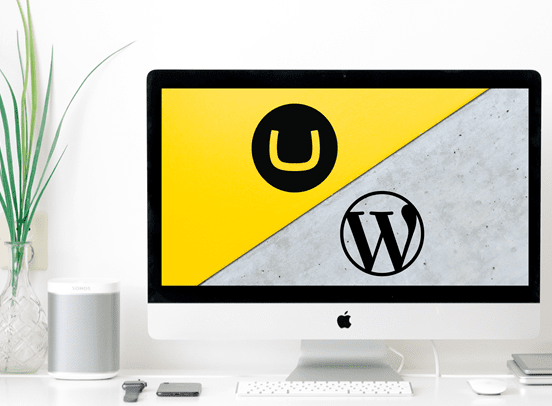 Umbraco vs Wordpress graphic on a Mac desktop in a minimalist workspace