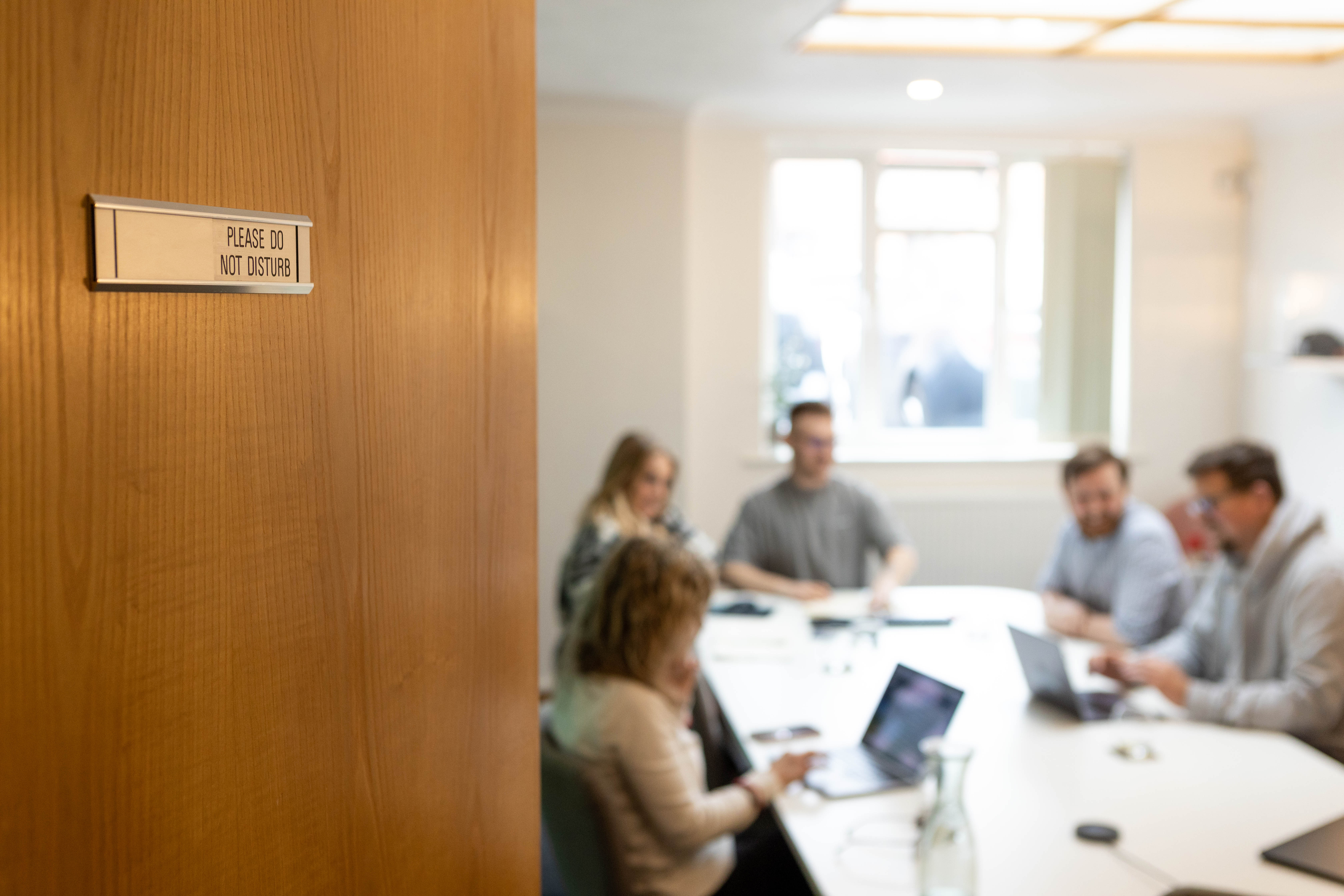 Looking into a Cold Banana boardroom meeting from the doorway