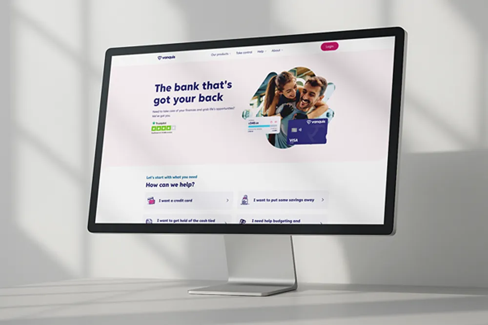Vanquis' homepage on a desktop monitor, with product navigation and customer task links.