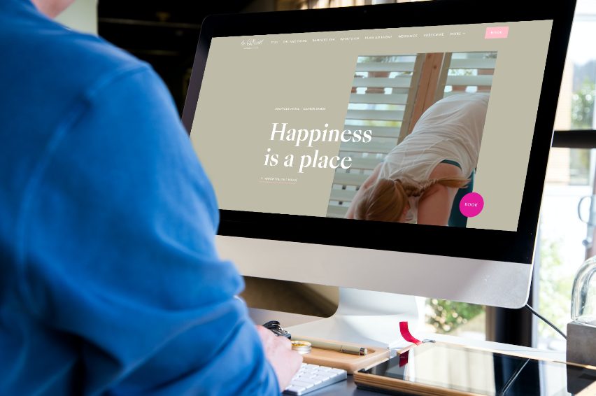 The Gallivant homepage on a desktop screen, with the line Happiness is a place and a book button.