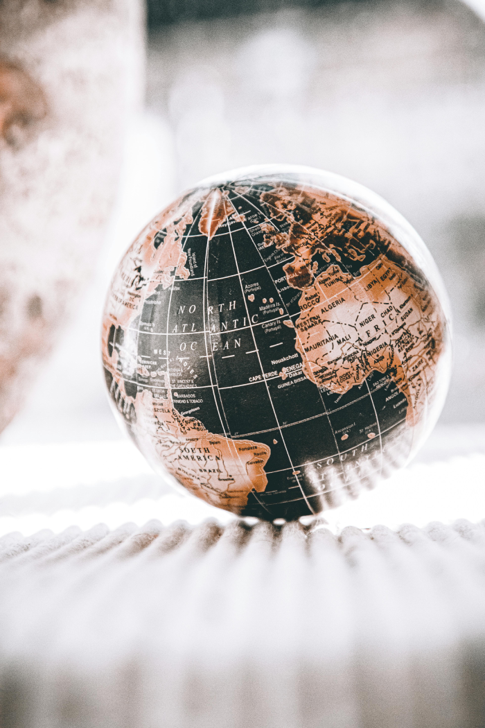 A black and tan globe on a cream coloured carpet.