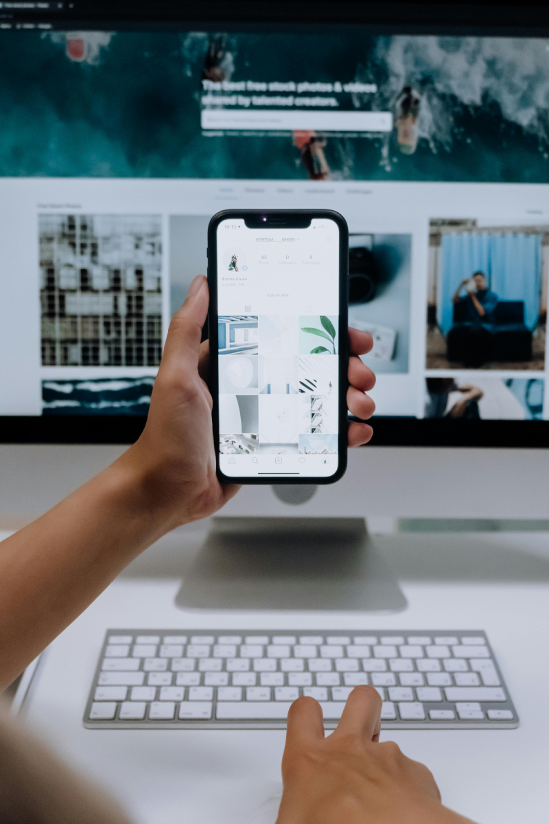 Digital Asset Management visual with a person comparing how images are displayed on a smartphone device and a desktop monitor
