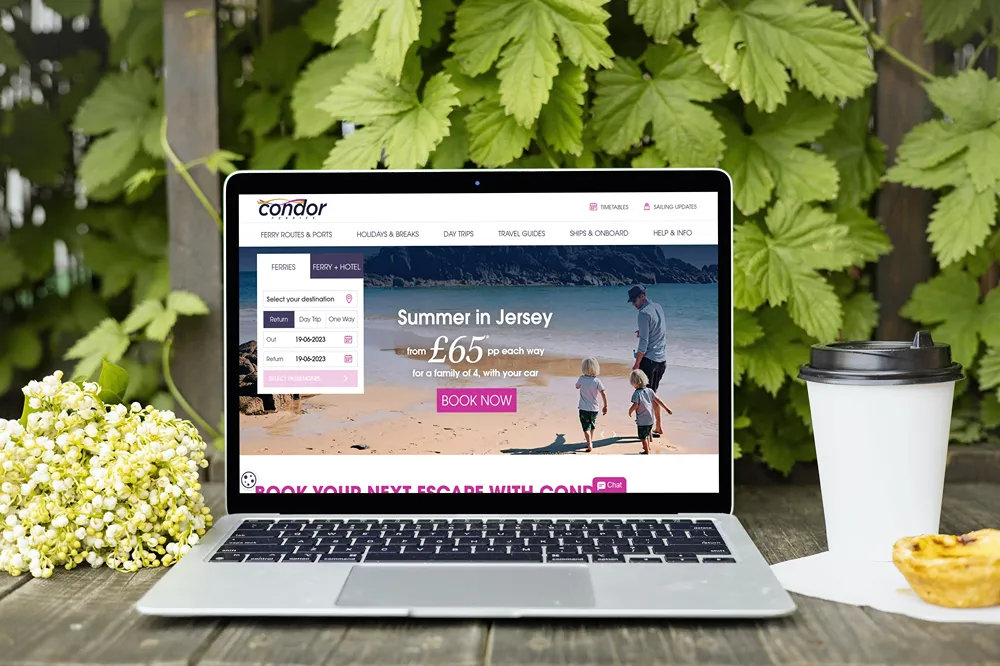 Condor Ferries' website on a laptop, with destination and travel date controls beside a Jersey promotion.