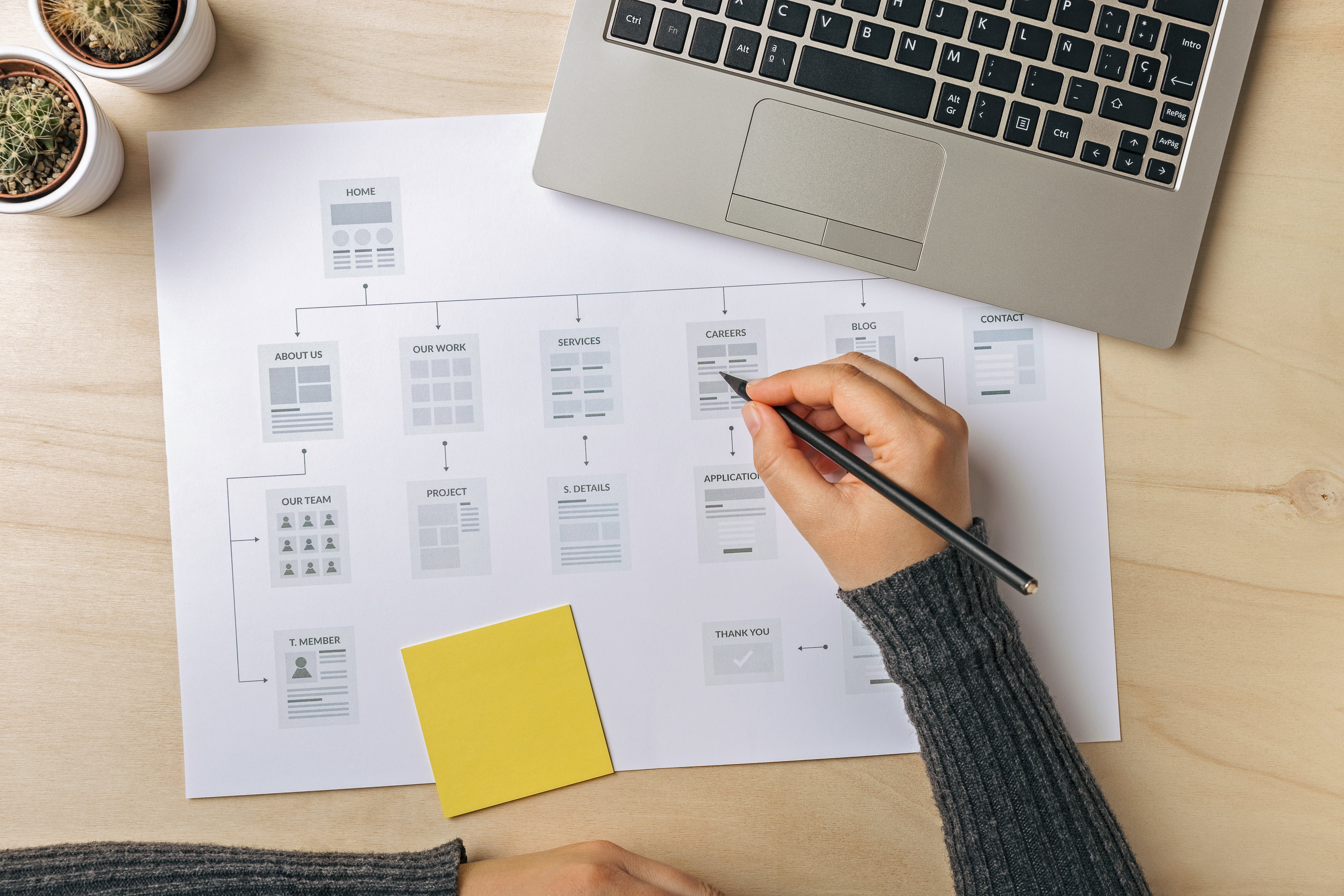 A person looking over a plan at their desk.