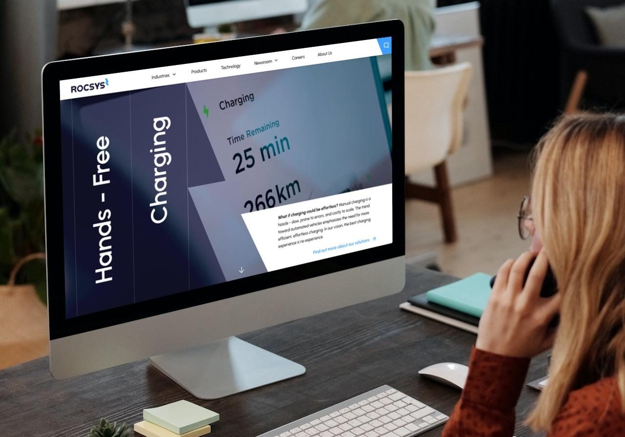 The Rocsys website on a desktop screen, showing hands-free charging and a 25 minute charge time.