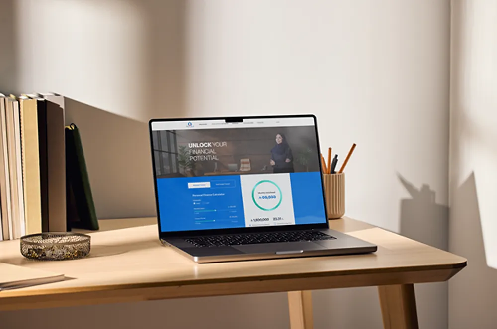 Amlak International's homepage on a laptop, with a personal finance calculator below the hero.