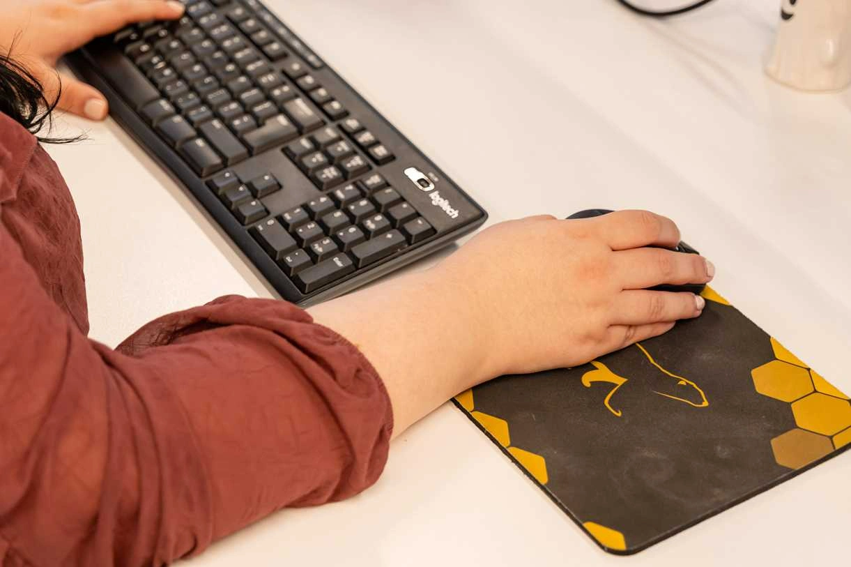A Cold Banana employee working at their desk with a branded CB mouse mat.