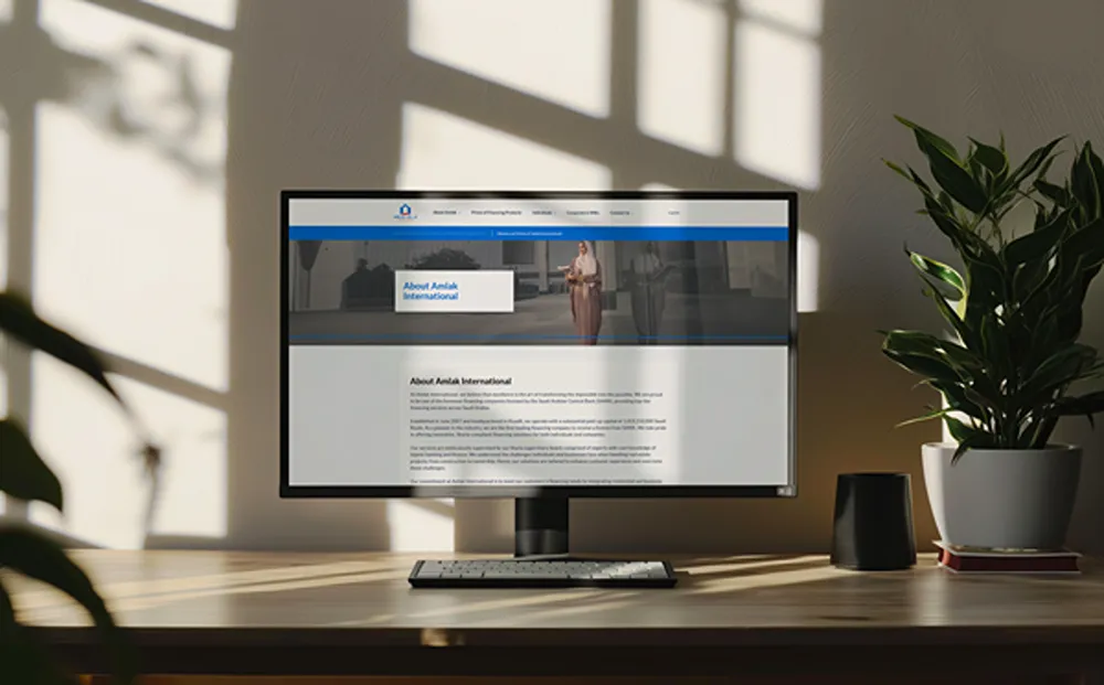 Amlak International's company information page displayed on a desktop monitor.
