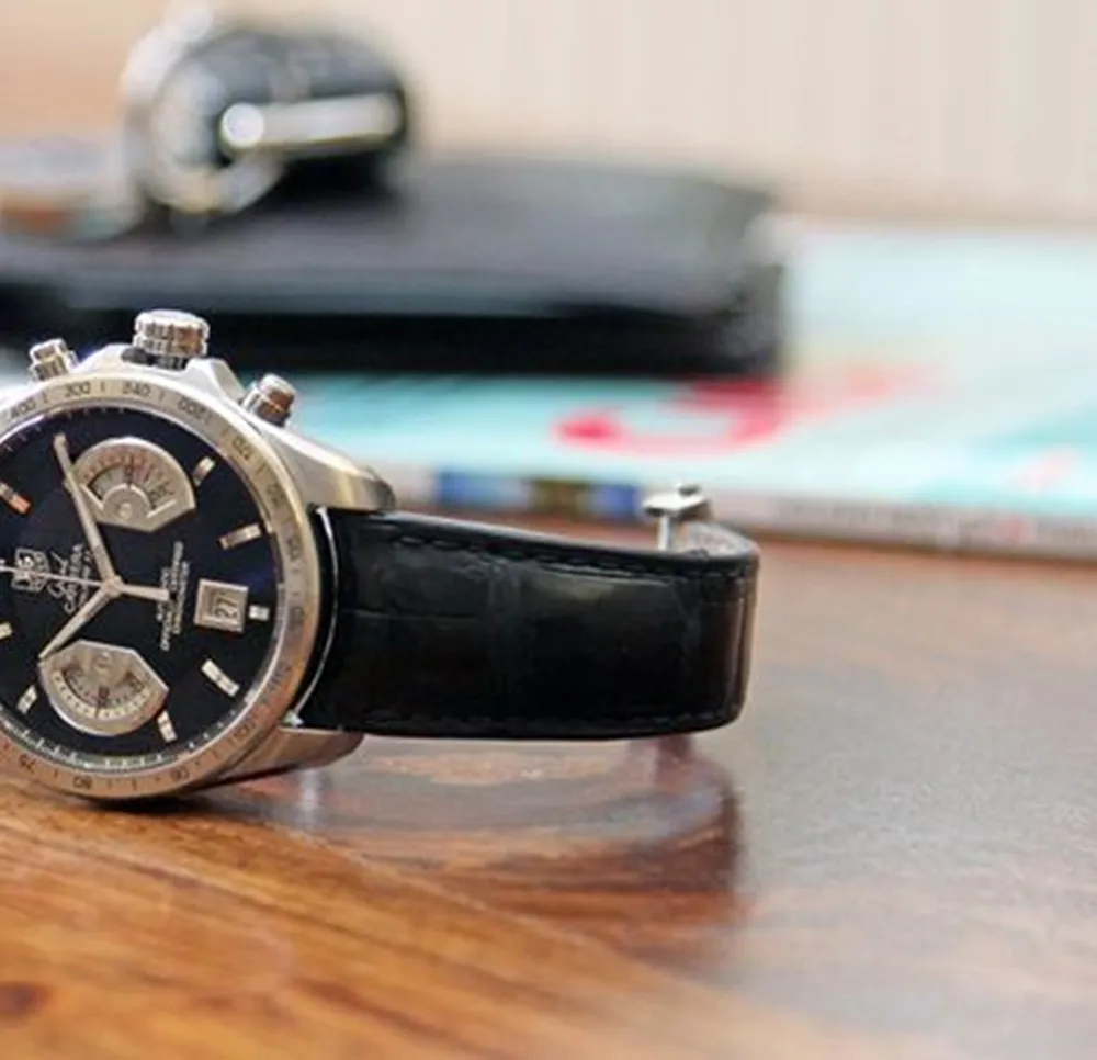 A watch on a wooden desk.